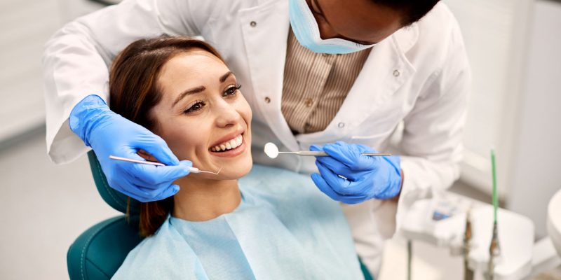 Happy woman having her teeth checked during appointment at dental clinic.